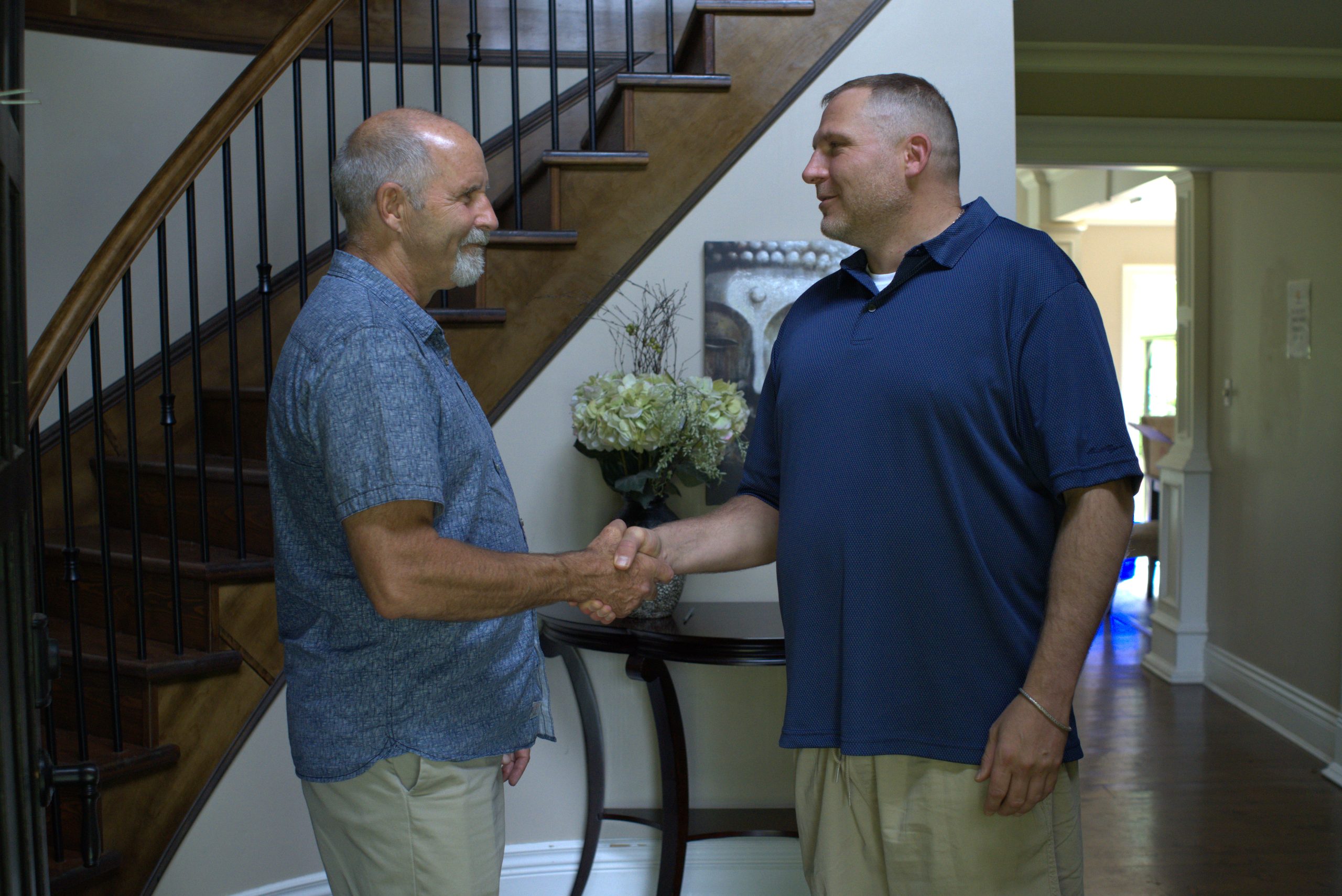 2 members of Into Action shaking hands inside the residential treatment center