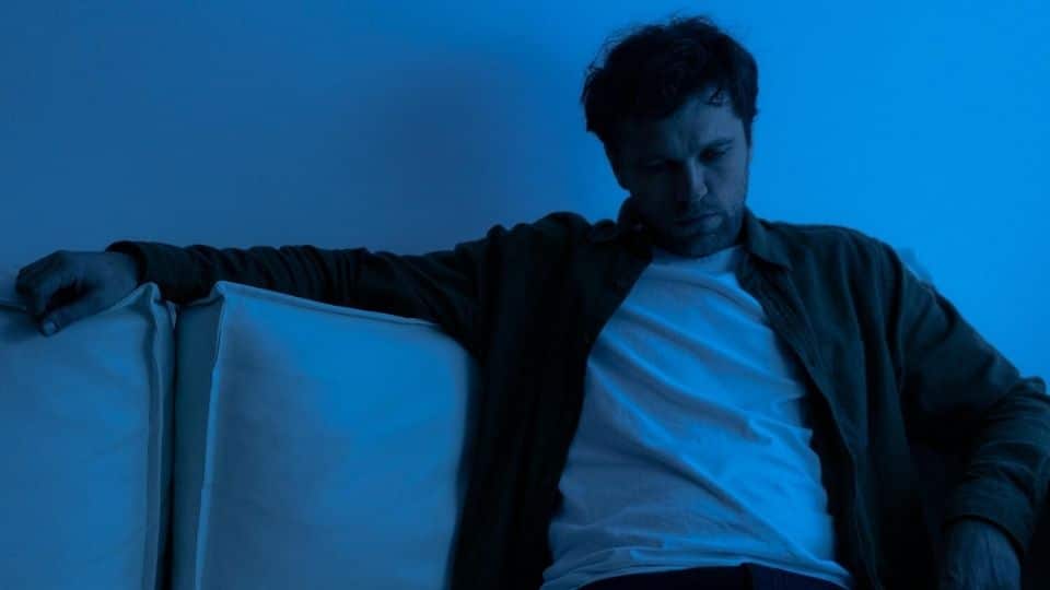 Alcoholic Man Thinking About His Addiction While on a Couch