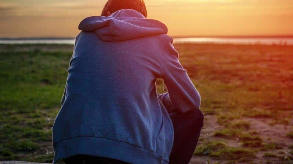 What Is the Hardest Addiction To Quit This sitting man wearing a hoodie figures it is alcohol.