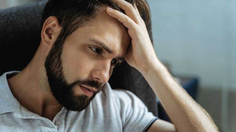 What Is the Hardest Addiction To Quit? a man holds his head while trying to figure it out.