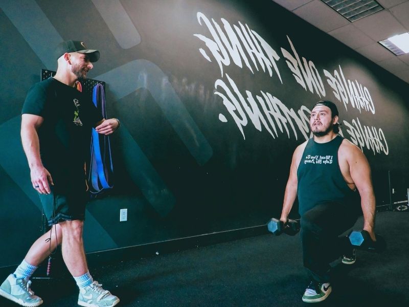 Two men who are working out enjoy being sober during IOP treatment
