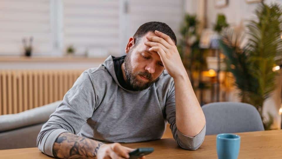 alcoholic nose can be caused by other things as well, a man researches this on his phone.