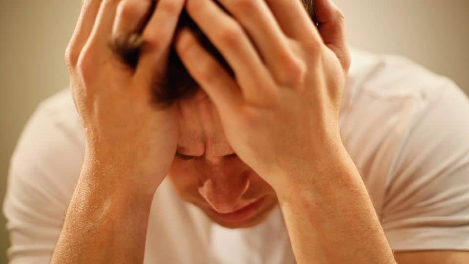 A man feels the duration of meth psychosis while holding his head